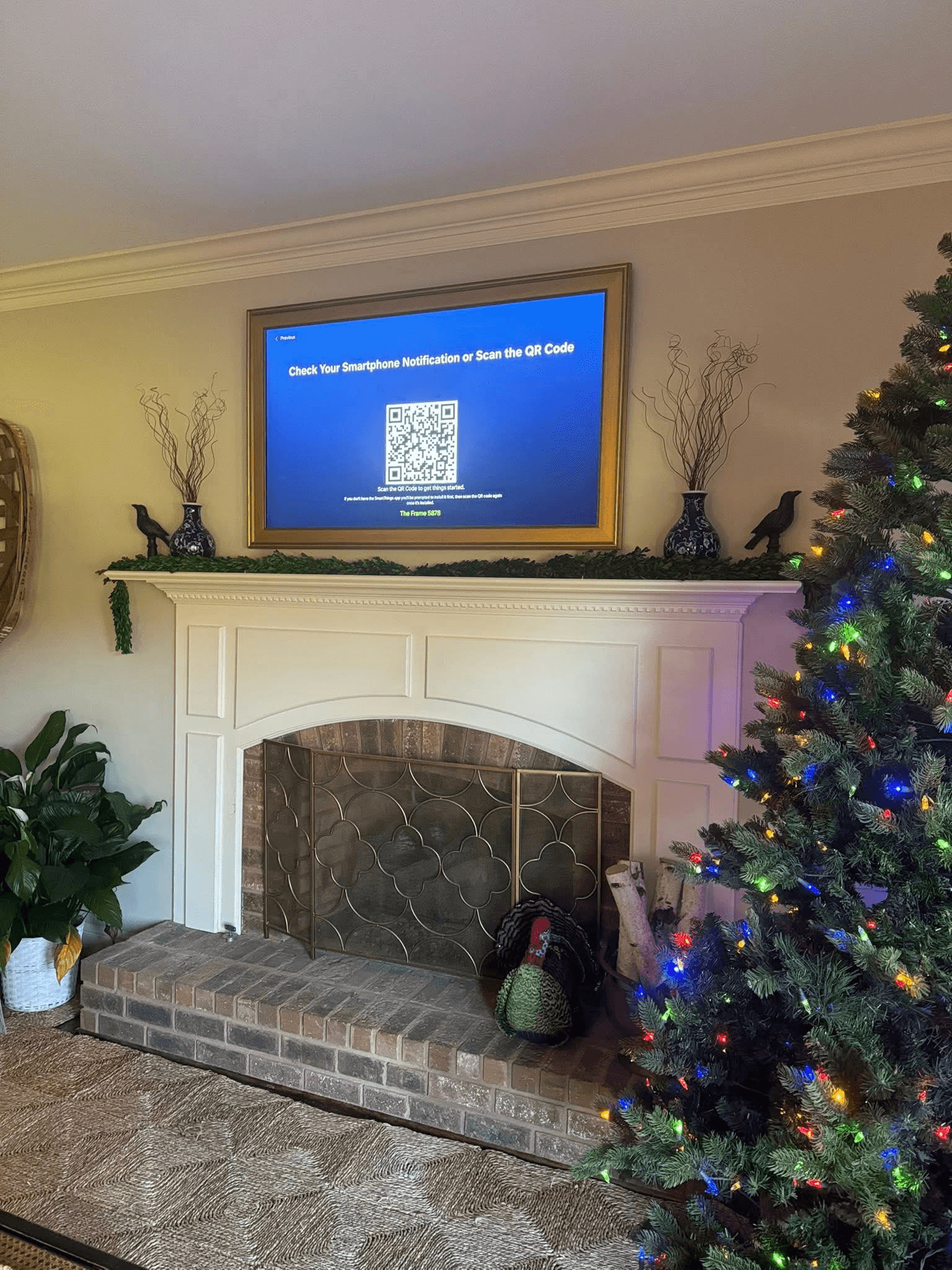 Samsung Frame TV with gold frame above fireplace during holidays