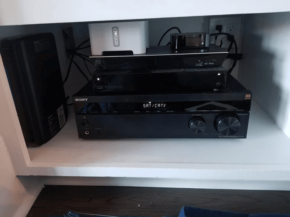 Sony AV receiver and streaming device stacked in media cabinet