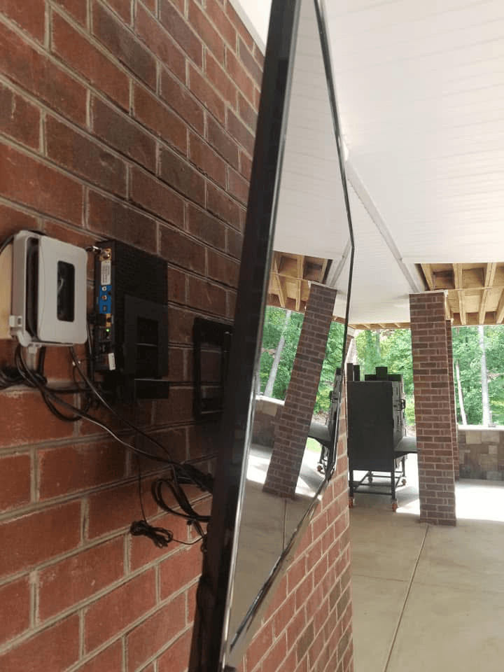 Side view of outdoor TV mount on brick with media box