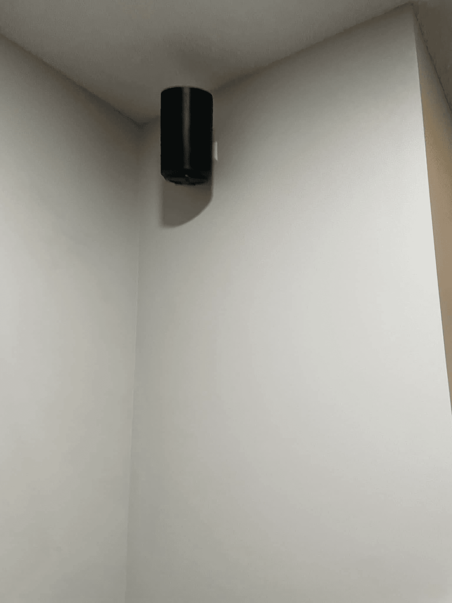 Black Sonos Era speaker ceiling-mounted in corner of room